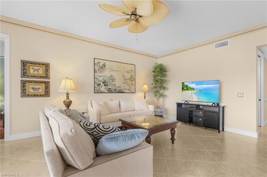 Tiled living room with ceiling fan and crown moldi