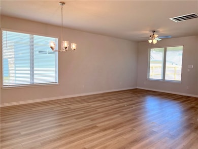 Spare room with a chandelier, light wood-type floo