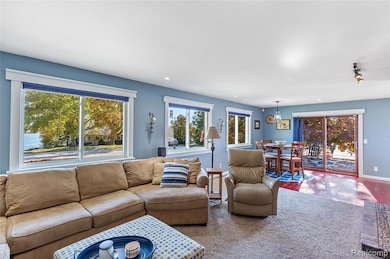 Living area with healthy amount of natural light, carpet/hardwood flooring, and remote control blinds