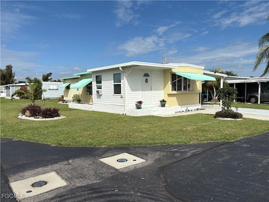 View of side of property with a yard, driveway, and a carport