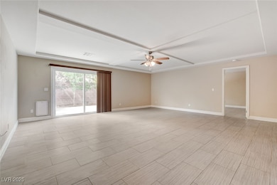 Empty room featuring a ceiling fan and baseboards