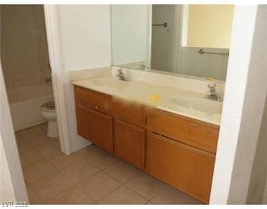 Full bathroom featuring light tile patterned floors and double vanity