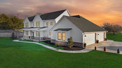 Back house at dusk with a lawn and a garage