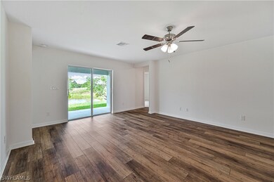 Empty room featuring ceiling fan and dark hardwood