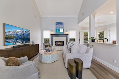 Living area featuring a warm lit fireplace, high 