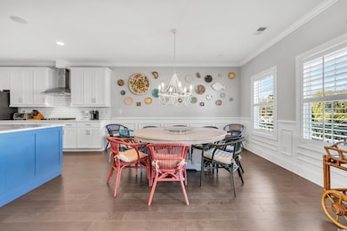 Dining room with a wainscoted wall, visible vents,
