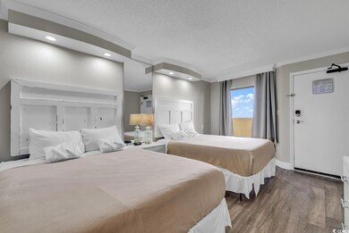 Bedroom featuring a textured ceiling, ornamental molding, and wood finished floors