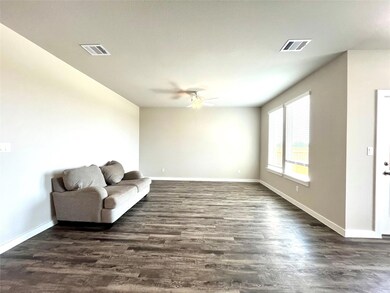 Living area with a ceiling fan, dark wood-type fl