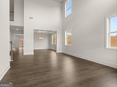 Westerly front entryway into two-story foyer with hardwood-like flooring