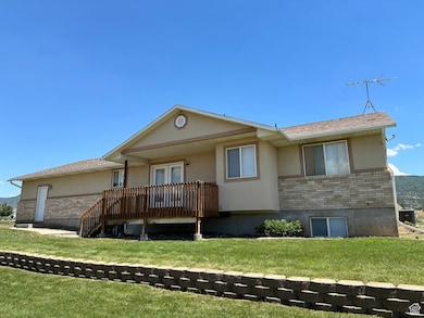 Rear view of house with brick siding, a yard, stucco siding, and roof with shingles