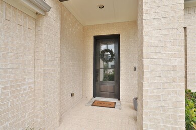 The covered front porch features a modern door and