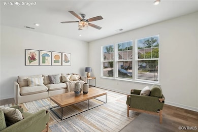 Living room featuring a ceiling fan, baseboards, w