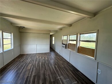 Unfurnished room featuring beamed ceiling and dark