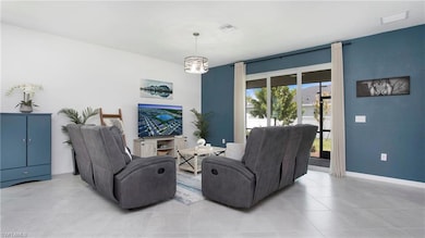 Living area with light tile patterned flooring, a chandelier, and baseboards