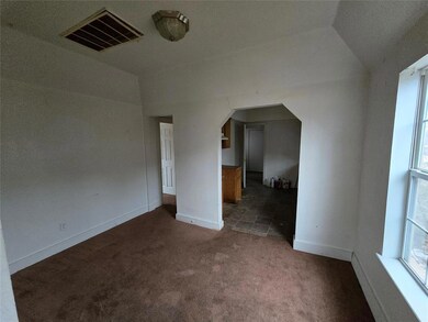 Empty room with vaulted ceiling and dark carpet