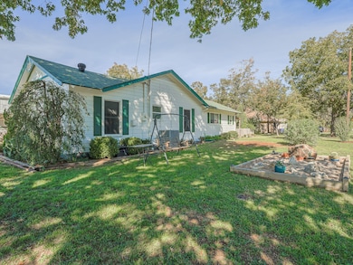 Side of property with a yard and large mature trees!