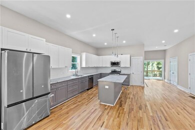 Kitchen with gray cabinetry, stainless steel appliances, backsplash, white cabinets, and recessed lighting
