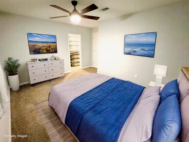Spacious master bedroom with plush carpeting and m