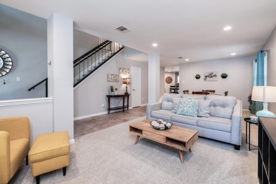 Living area with recessed lighting, stairway, and carpet