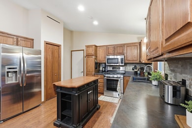 Another look at the kitchen with stainless fridge, gas range and pantry closet.