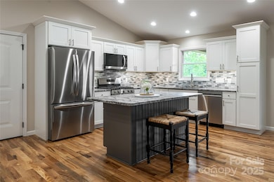 The kitchen features stainless steel appliances and an island