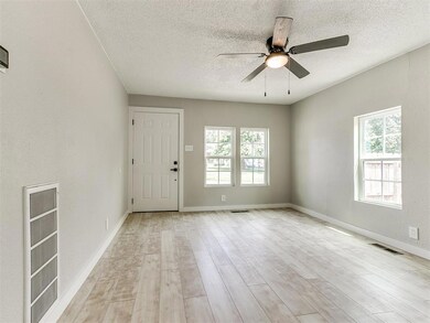 Empty room featuring a textured ceiling, ceiling f