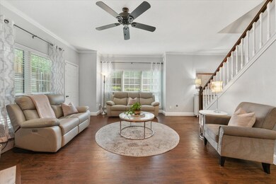 Living room featuring ceiling fan, a fireplace, an