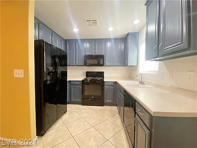 Kitchen featuring visible vents, a sink, light til