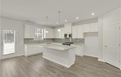 Kitchen featuring stainless steel microwave, stove, a sink, backsplash, and recessed lighting