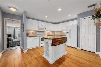 The OPEN KITCHEN features tons of CABINET STORAGE, matching appliances, a TILED BACKSPLASH and an ISLAND with prep space.