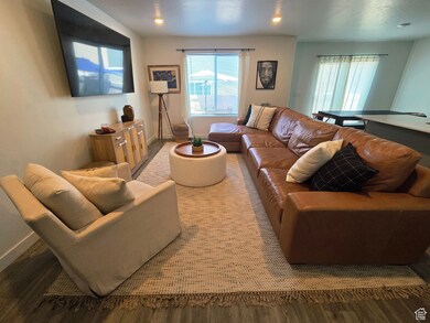 Living area featuring laminate floors and recessed lighting