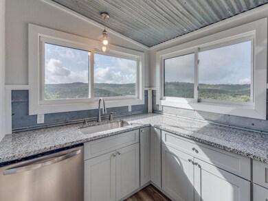 Kitchen with dishwasher, light stone counters, de