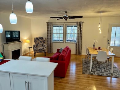 Living room with a ceiling fan, and light wood-style flooring