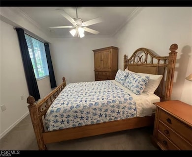 Bedroom featuring crown molding, ceiling fan, and dark carpet