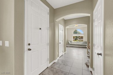 Corridor featuring arched walkways, light tile pat