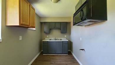 Laundry area with dark wood finished floors and a textured ceiling