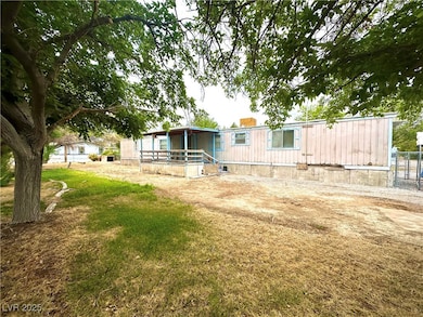 Rear view of property featuring a lawn and fence