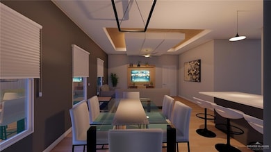 Dining area with baseboards, light wood-style flooring, and a raised ceiling