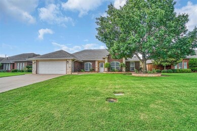 View of front of property featuring a garage, driveway, a front yard, brick siding, and roof with shingles