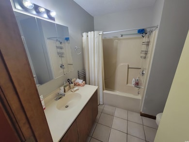 Bathroom featuring tile patterned flooring, shower / bath combo, and vanity