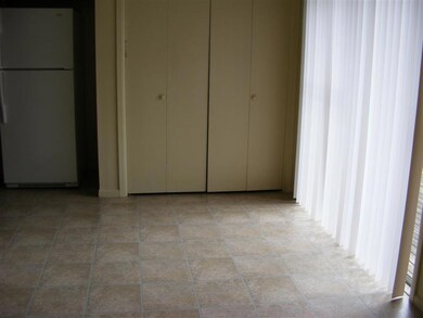 Unfurnished bedroom featuring freestanding refrige
