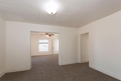 Unfurnished room with baseboards, ceiling fan, and