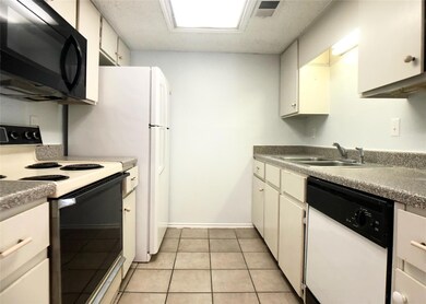 Kitchen with a sink, black microwave, dishwasher,