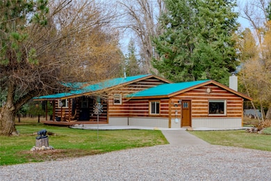 Cabin featuring a front lawn, a metal roof, and a chimney