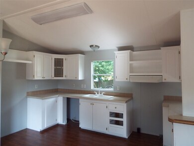 A partial view of the kitchen with freshly painted cabinets. Counter Tops and appliances to be installed prior to closing.