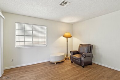 Sitting room with a textured ceiling, baseboards,