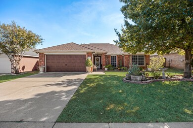 Ranch-style house featuring brick siding, roof with shingles, a front yard, and driveway