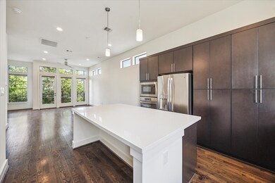 The kitchen is well-lit with pendant lights and na