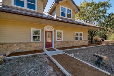 Property entrance featuring stone siding, a metal