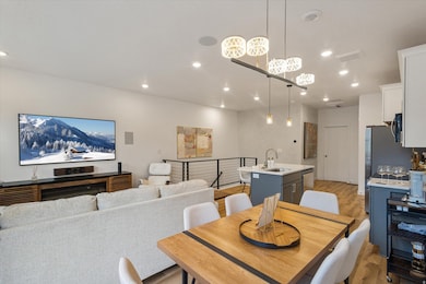 Dining area with light wood-type flooring and recessed lighting